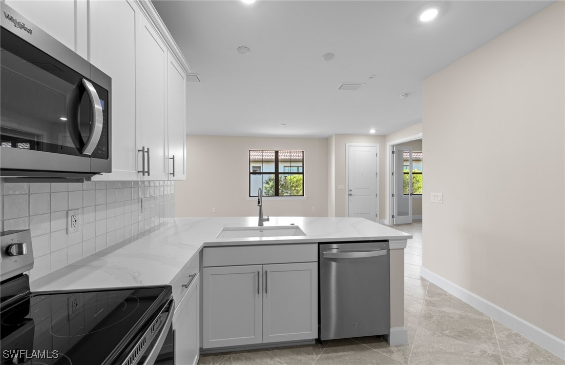16784 Rolling Rock Boulevard Alva, FL 33920 - Photo 7 of 29 a kitchen with a sink and a microwave