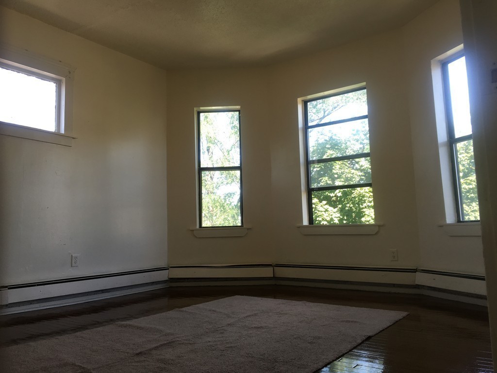 31 Iffley Road Boston, MA 02130 - Photo 12 of 21 a view of an empty room with wooden floor and a window