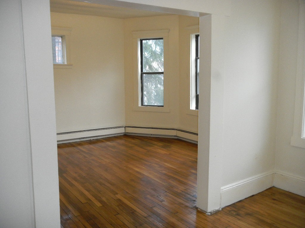 31 Iffley Road Boston, MA 02130 - Photo 5 of 21 a view of an empty room with wooden floor and a window