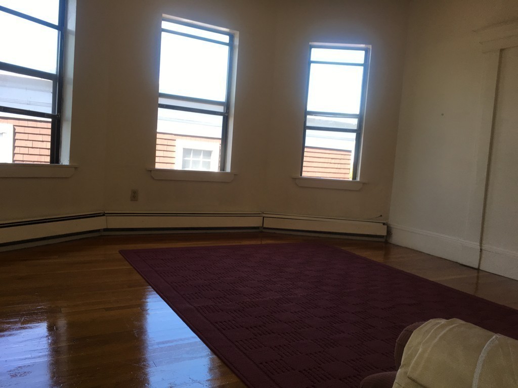 31 Iffley Road Boston, MA 02130 - Photo 7 of 21 a view of an empty room with wooden floor and a window