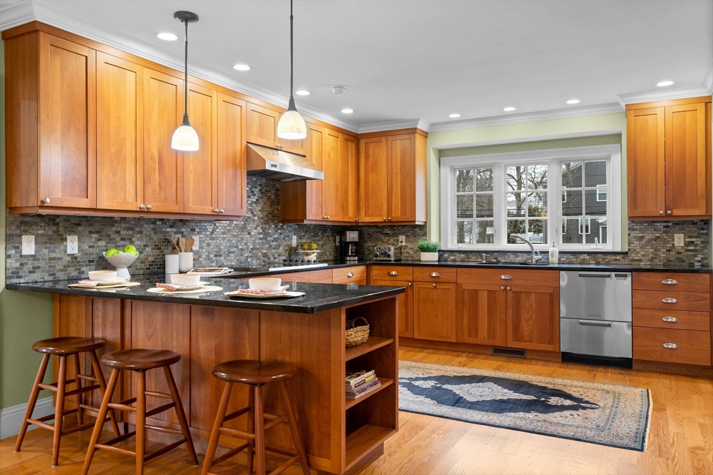 322 Ridge Street Arlington, MA 02474 - Photo 3 of 42 a kitchen with stainless steel appliances granite countertop wooden cabinets a sink a stove a dining table and chairs