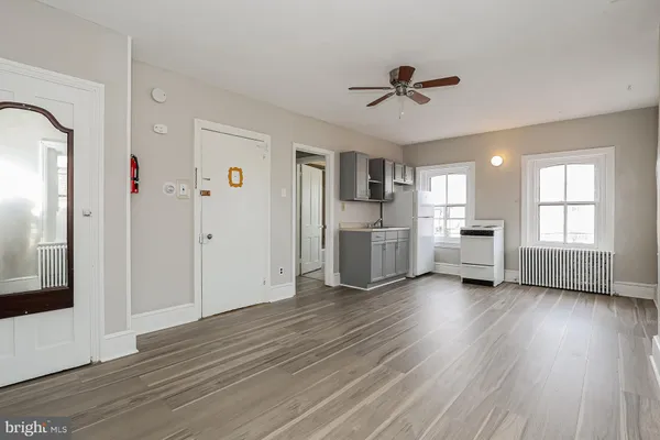 a view of empty room with wooden floor and window