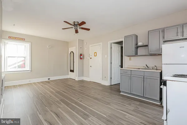 a kitchen with a refrigerator and white cabinets