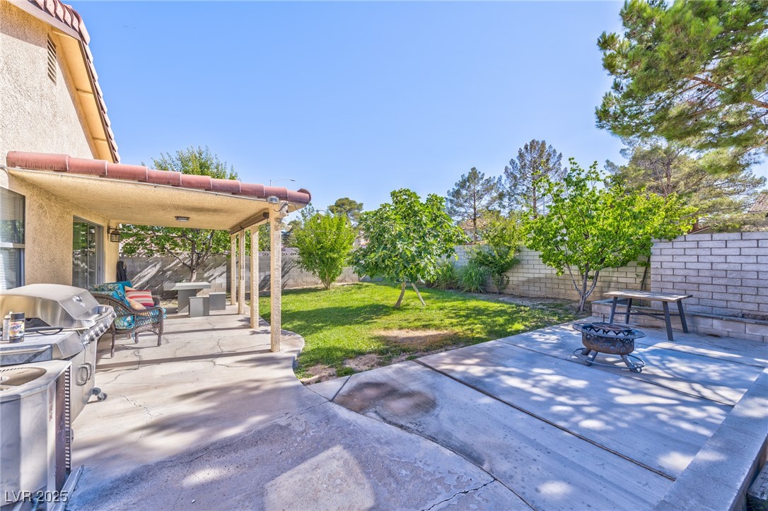 640 Whispering Palms Drive Las Vegas, NV 89123 - Photo 13 of 16 Fenced backyard featuring an outdoor fire pit and a patio area