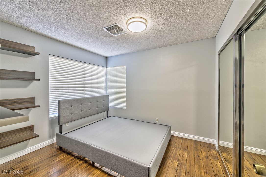640 Whispering Palms Drive Las Vegas, NV 89123 - Photo 7 of 16 Bedroom featuring dark wood finished floors, a textured ceiling, and a closet