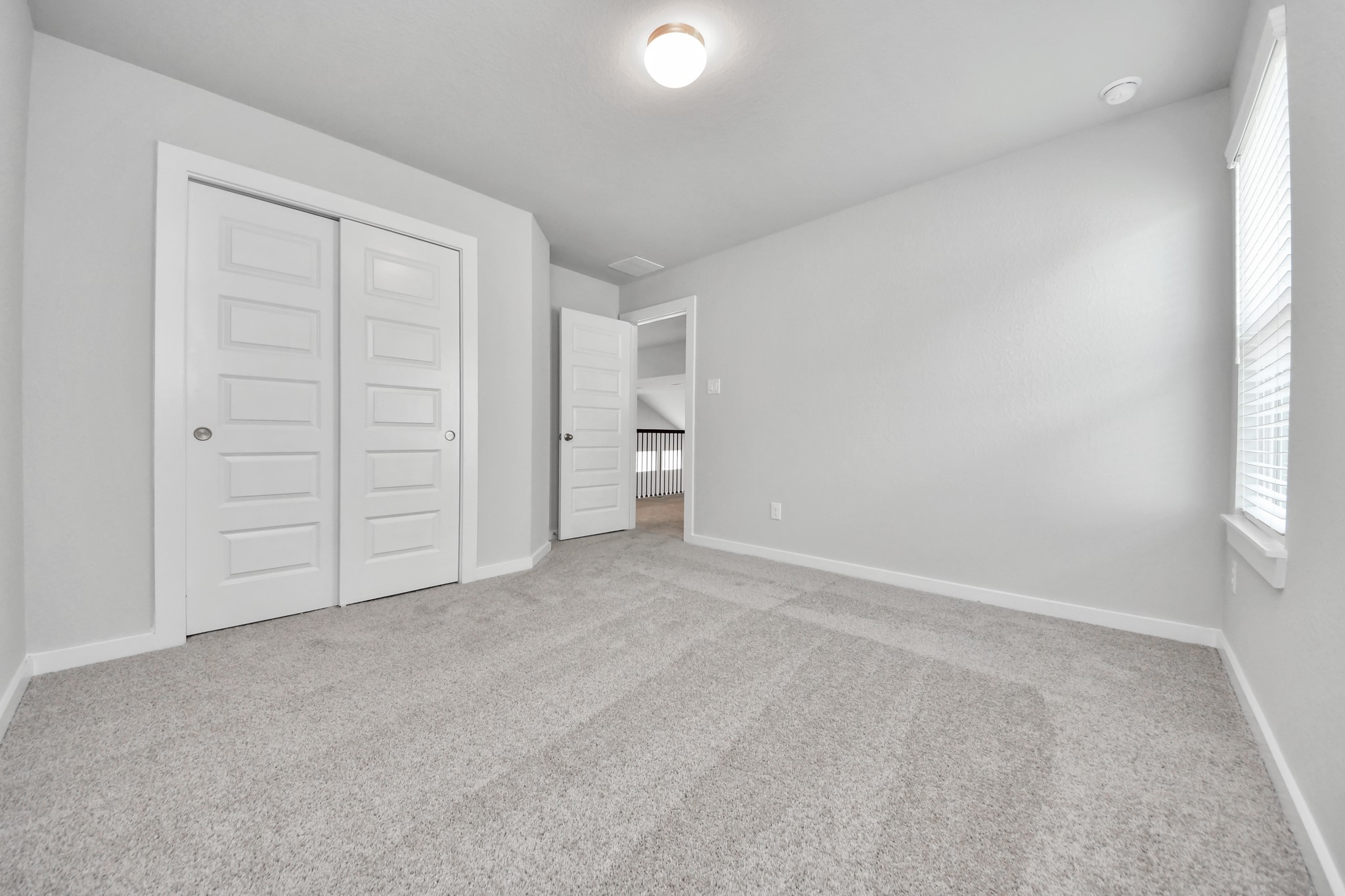 11114 Tulip Rdg Trail Houston, TX 77044 - Photo 28 of 30 Generously sized secondary bedrooms featuring spacious closets, soft and inviting carpeting underfoot, large windows allowing plenty of natural light, and the added touch of privacy blinds for your personal retreat. Sample photo of completed home with similar floor plan. Actual colors and selections may vary.