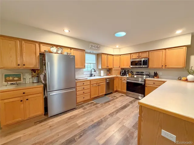 a kitchen with stainless steel appliances a refrigerator sink and cabinets