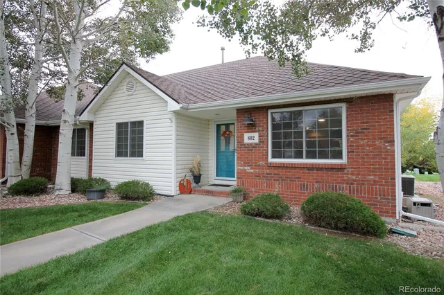 a front view of a house with a yard and trees