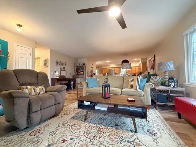 a living room with furniture a flat screen tv and a window