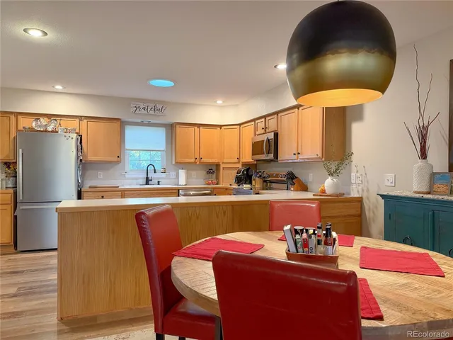 a kitchen with granite countertop a refrigerator stove top oven a sink and dishwasher