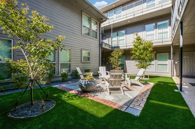 a view of a chair and table in backyard of the house