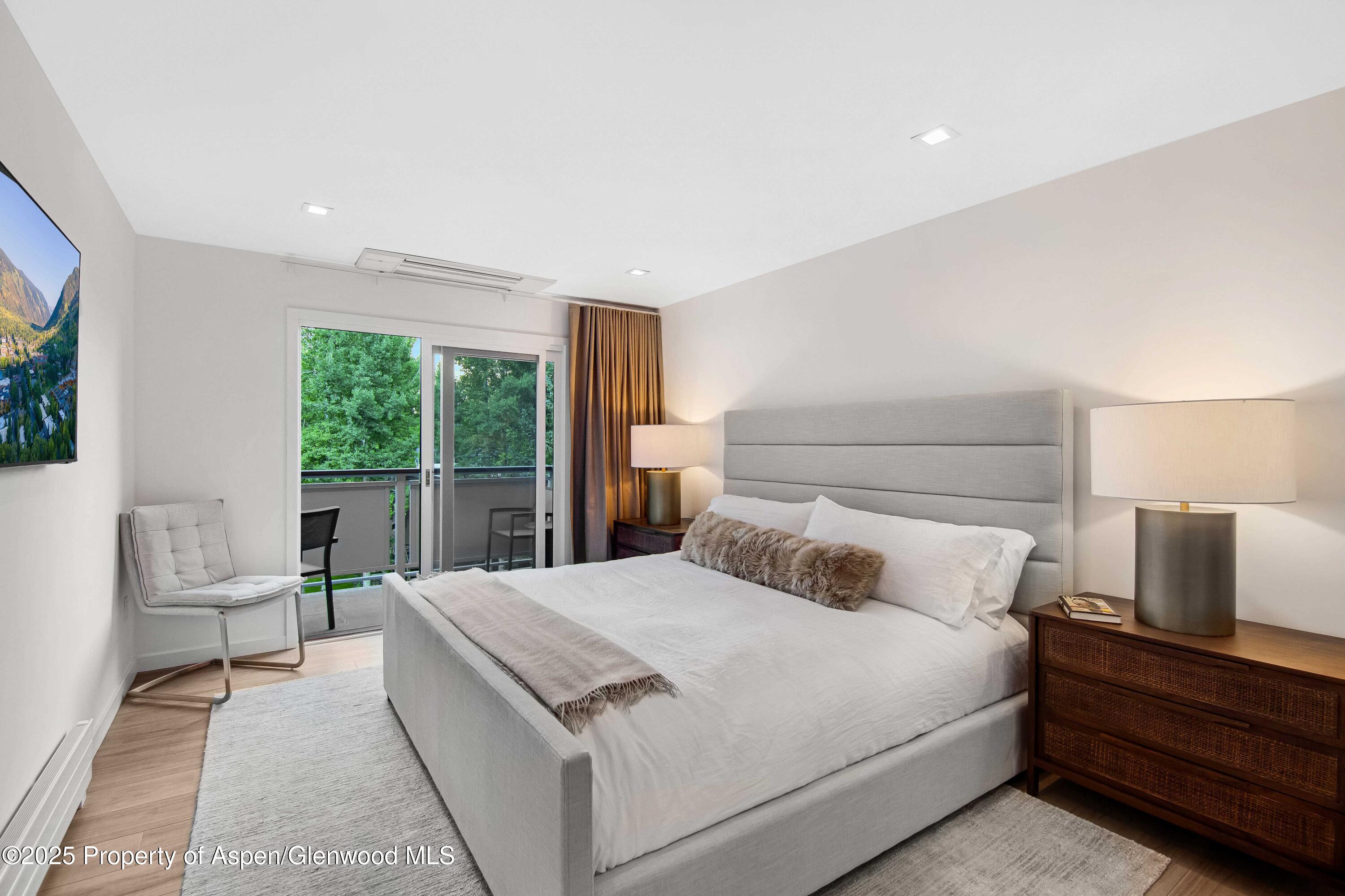 100 East Dean Street, Unit 3B Aspen, CO 81611 - Photo 7 of 16 a bedroom with a bed and glass window