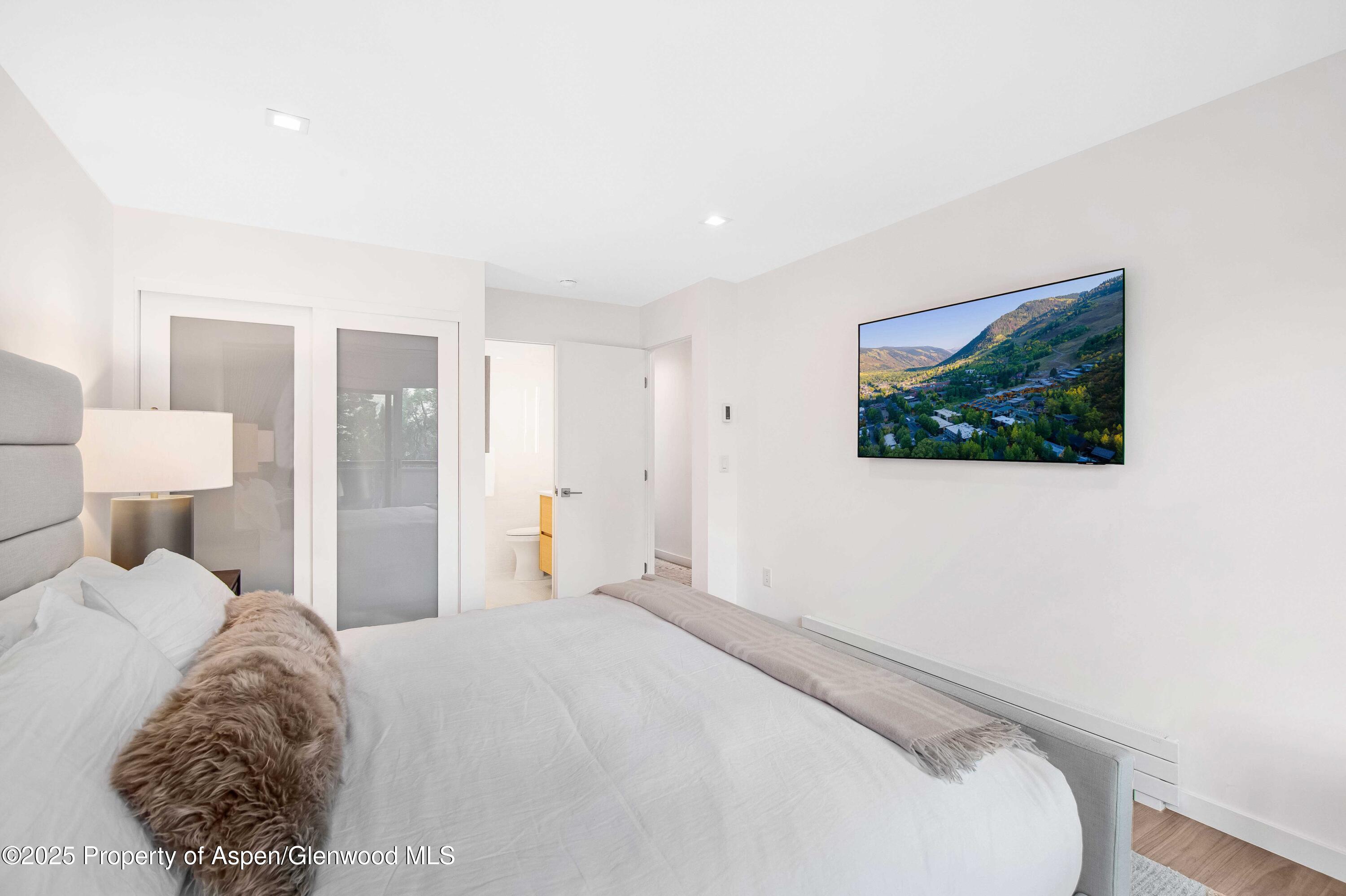 100 East Dean Street, Unit 3B Aspen, CO 81611 - Photo 8 of 16 a bedroom with a bed and a painting on the wall