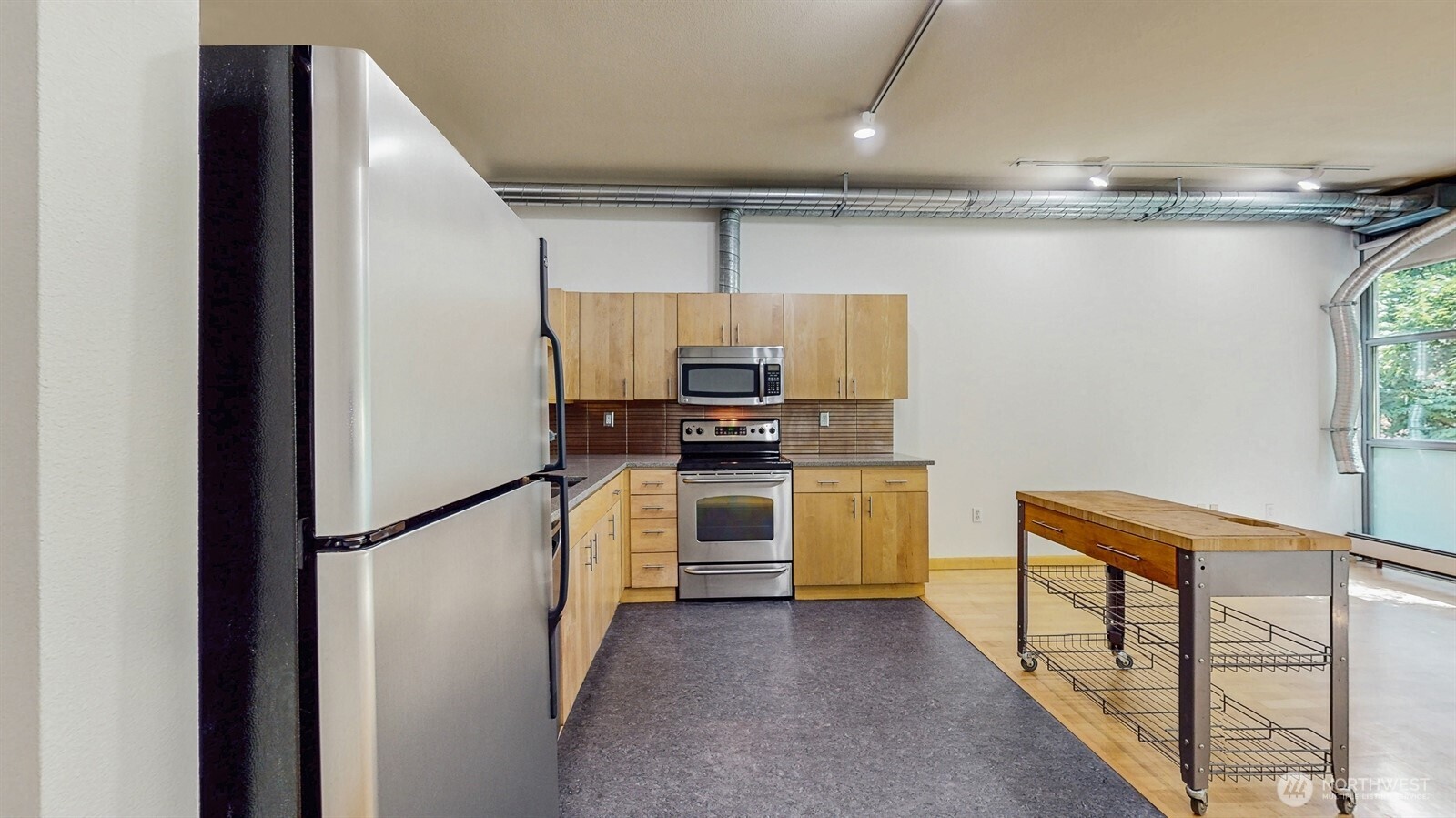 2015 Terry Avenue, Unit 301 Seattle, WA 98121 - Photo 9 of 14 a kitchen with stainless steel appliances a refrigerator and a stove top oven