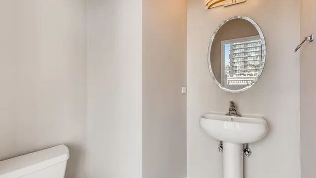 a bathroom with a sink toilet and a mirror