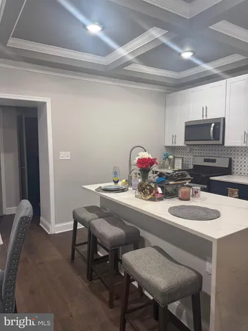 a table with chairs a stove and a refrigerator