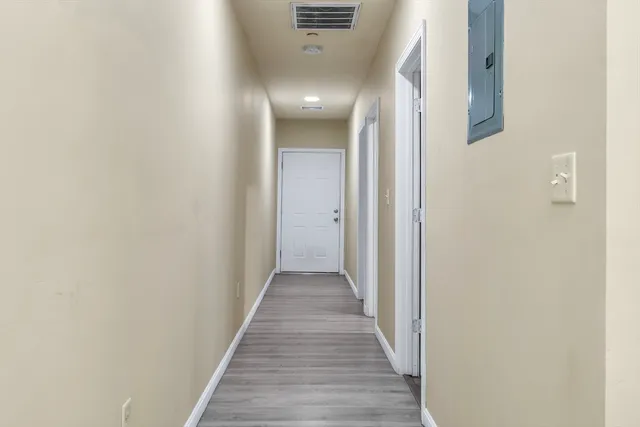 a view of a hallway with wooden floor