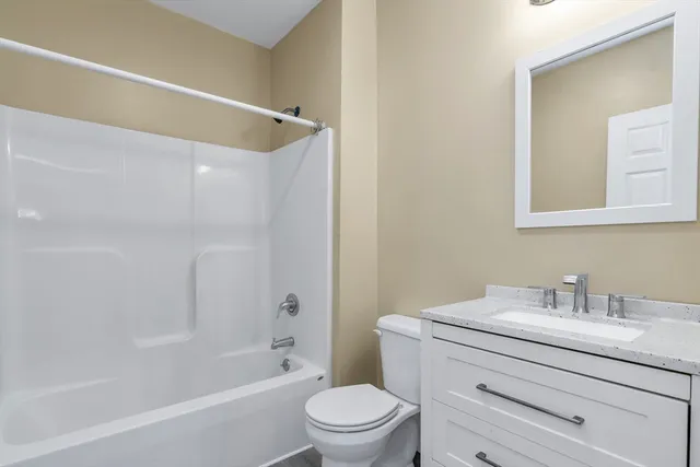 a bathroom with a sink a mirror a toilet and a bathtub