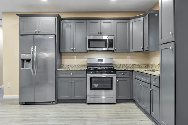 a kitchen with stainless steel appliances granite countertop a refrigerator stove and sink