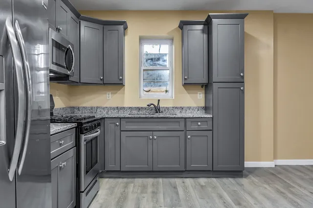 a kitchen with stainless steel appliances granite countertop a refrigerator sink and stove