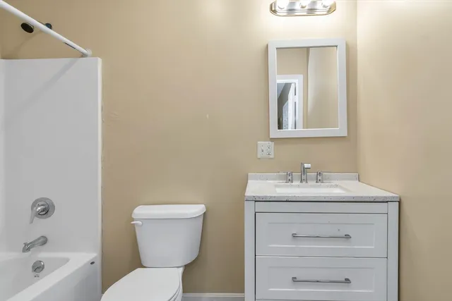 a bathroom with a sink a toilet and mirror