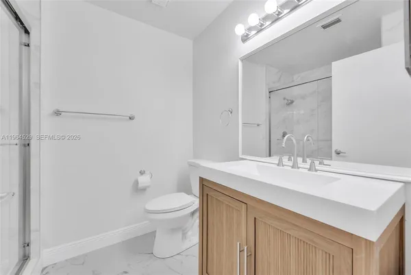 a bathroom with a sink a toilet a mirror and vanity