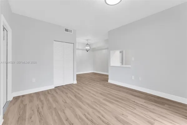 an empty room with wooden floor and windows