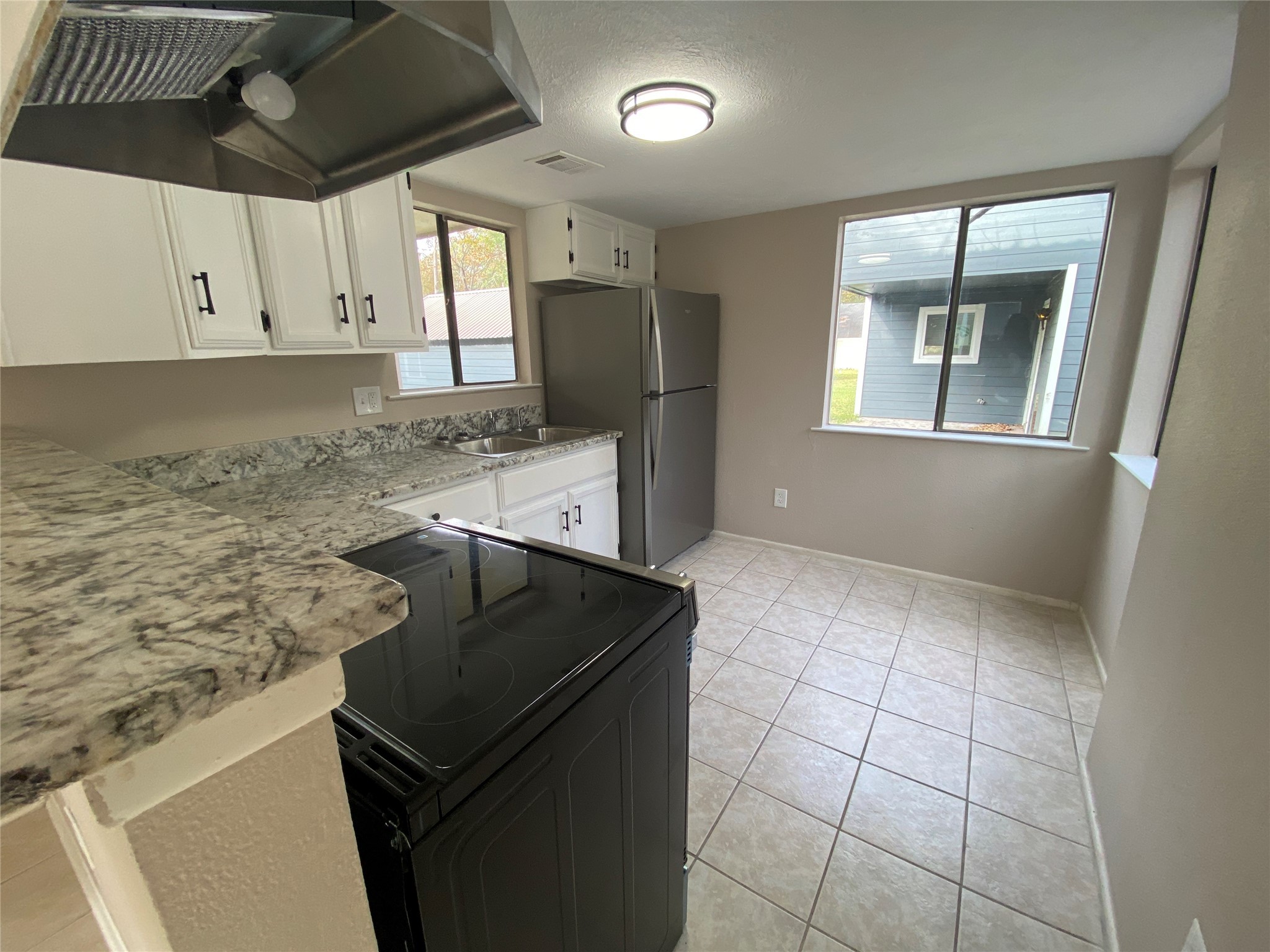 26620 Orchid Court Point Blank, TX 77364 - Photo 7 of 21 a kitchen with granite countertop a stove a sink and a refrigerator
