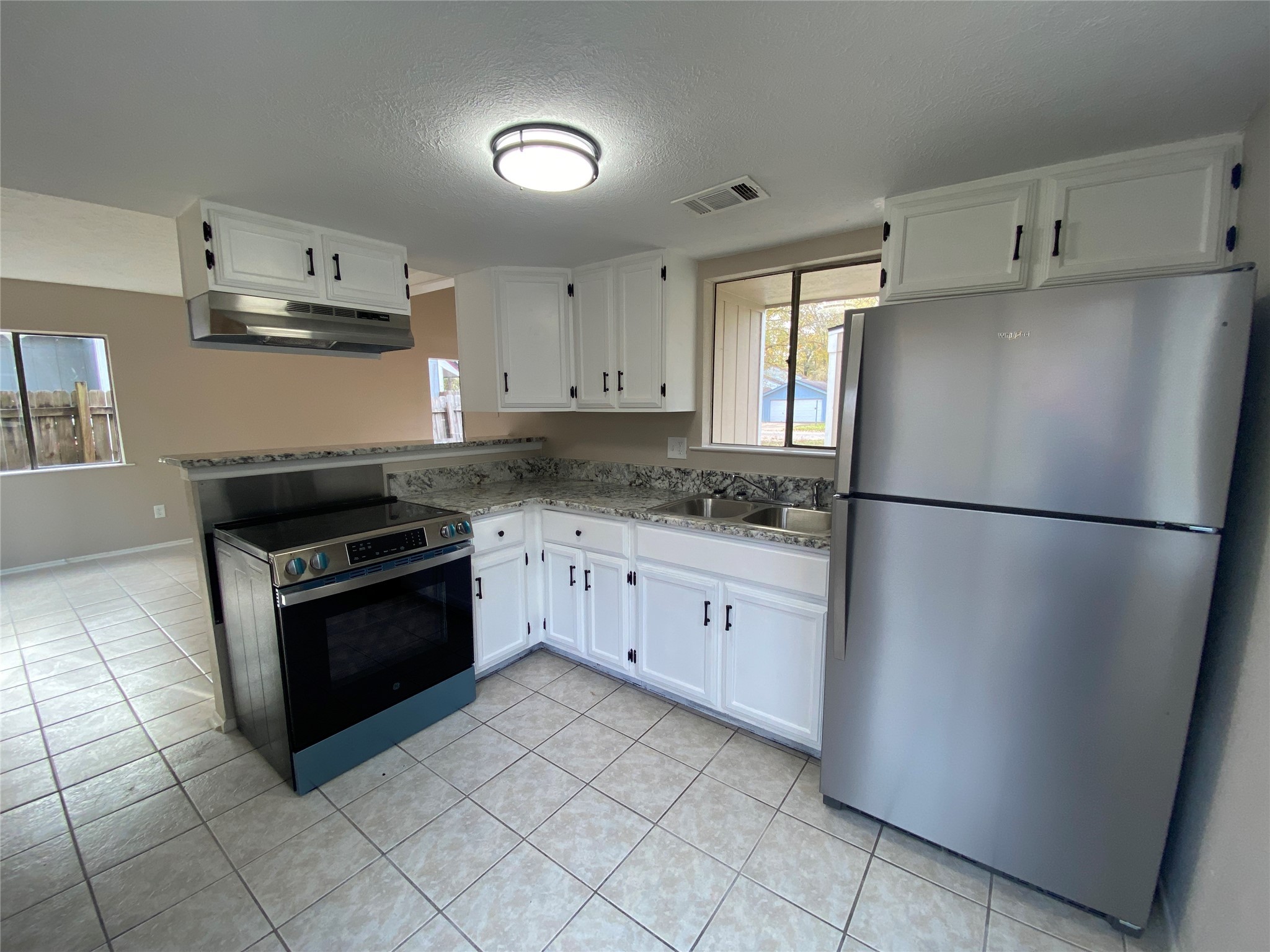 26620 Orchid Court Point Blank, TX 77364 - Photo 9 of 21 a kitchen with granite countertop a refrigerator and a stove top oven