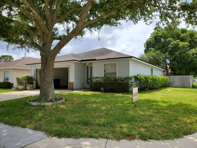 a front view of house with yard and green space