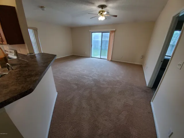 a view of a livingroom with a ceiling fan and window