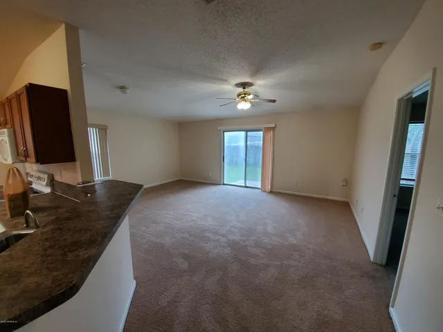 a view of a livingroom with a ceiling fan and window