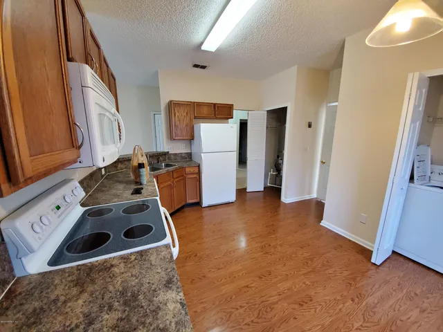 a kitchen with a sink a refrigerator a microwave a stove and cabinets
