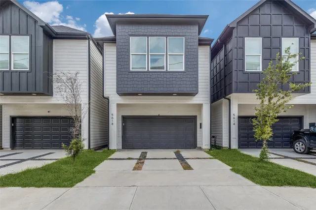 a front view of a house with a yard and a garage