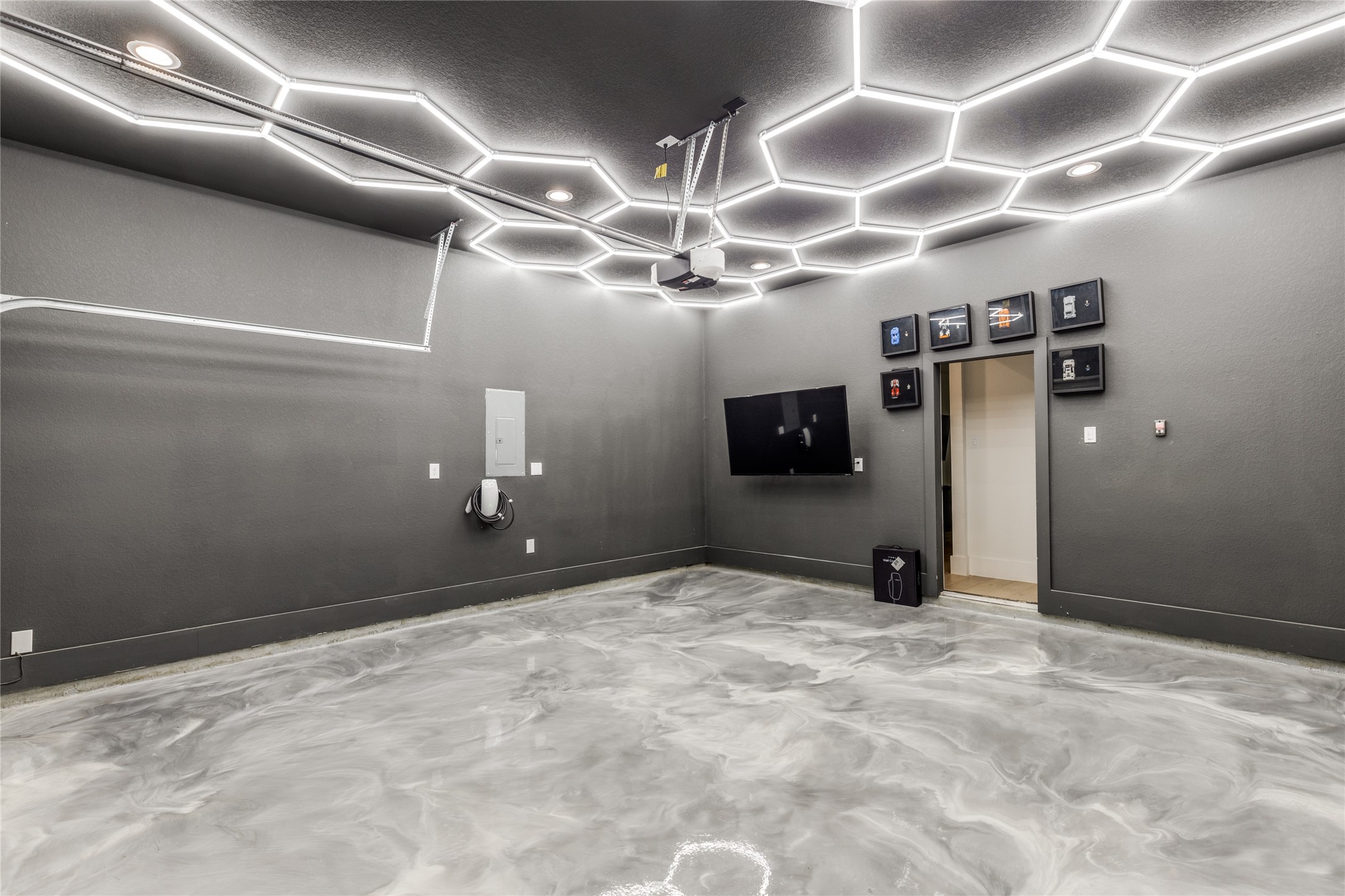 5618 Canal Street Houston, TX 77011 - Photo 12 of 12 Garage with an EV Tesla charging station. A metallic epoxy flooring. Custom LED hexagon lighting.