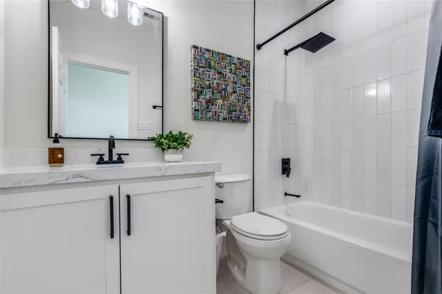a bathroom with a granite countertop sink a toilet a mirror a vanity and shower