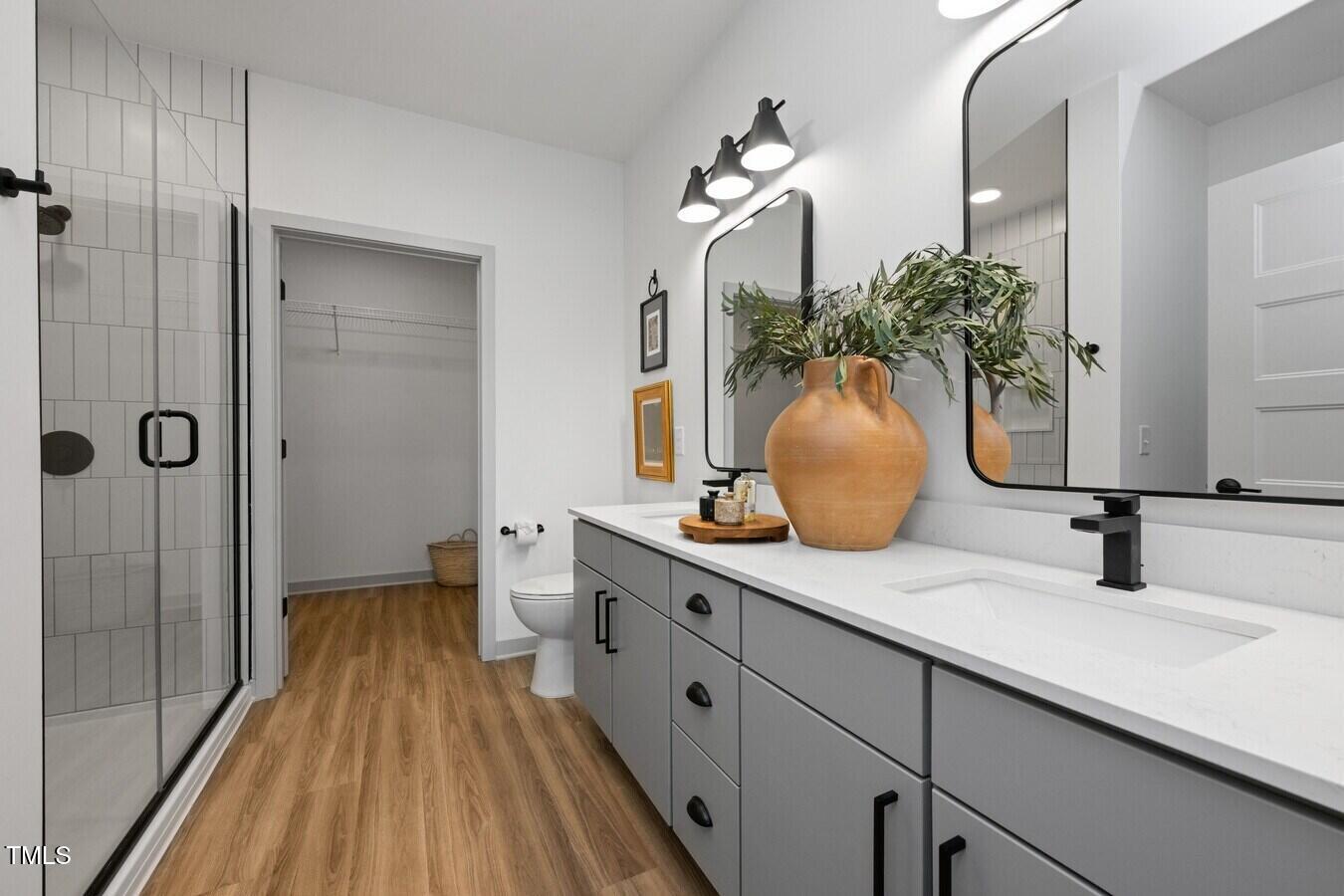 3901 Capital Hills Drive, Unit C1A Raleigh, NC 27616 - Photo 29 of 35 a bathroom with a double vanity sink and a mirror
