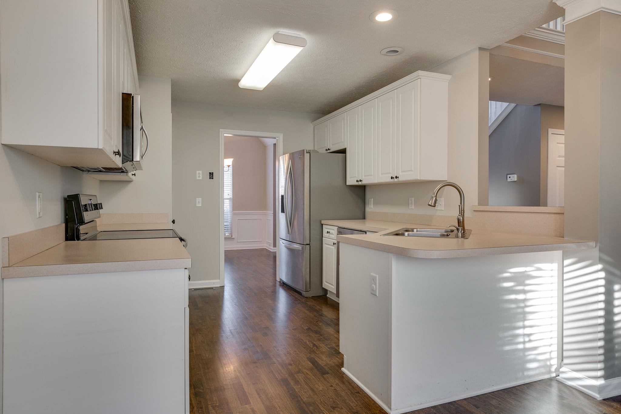 391 Abbie Road Murfreesboro, TN 37128 - Photo 13 of 30 a kitchen with stainless steel appliances a sink stove and wooden floor