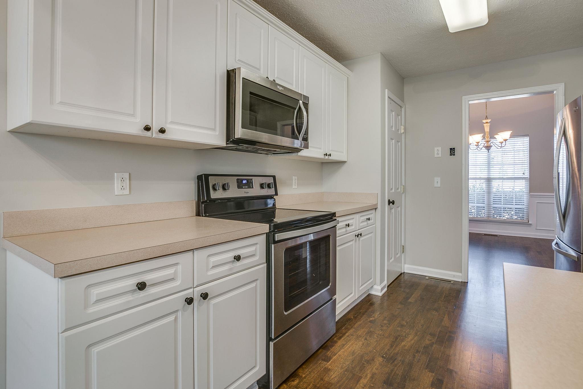 391 Abbie Road Murfreesboro, TN 37128 - Photo 14 of 30 a kitchen with stainless steel appliances granite countertop a stove a sink and a microwave
