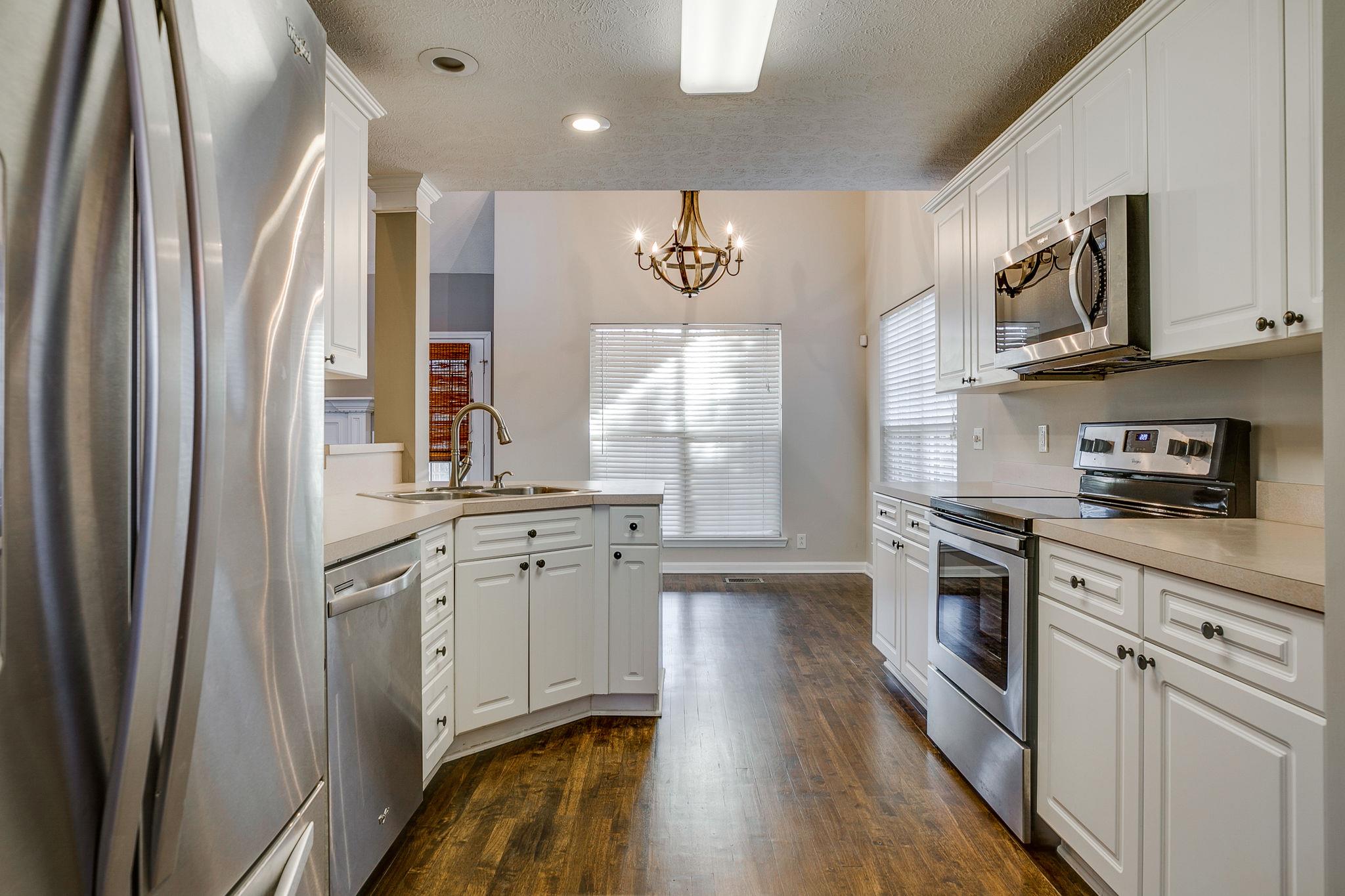 391 Abbie Road Murfreesboro, TN 37128 - Photo 15 of 30 a kitchen with stainless steel appliances granite countertop a refrigerator a sink dishwasher a stove and white countertops with wooden floor