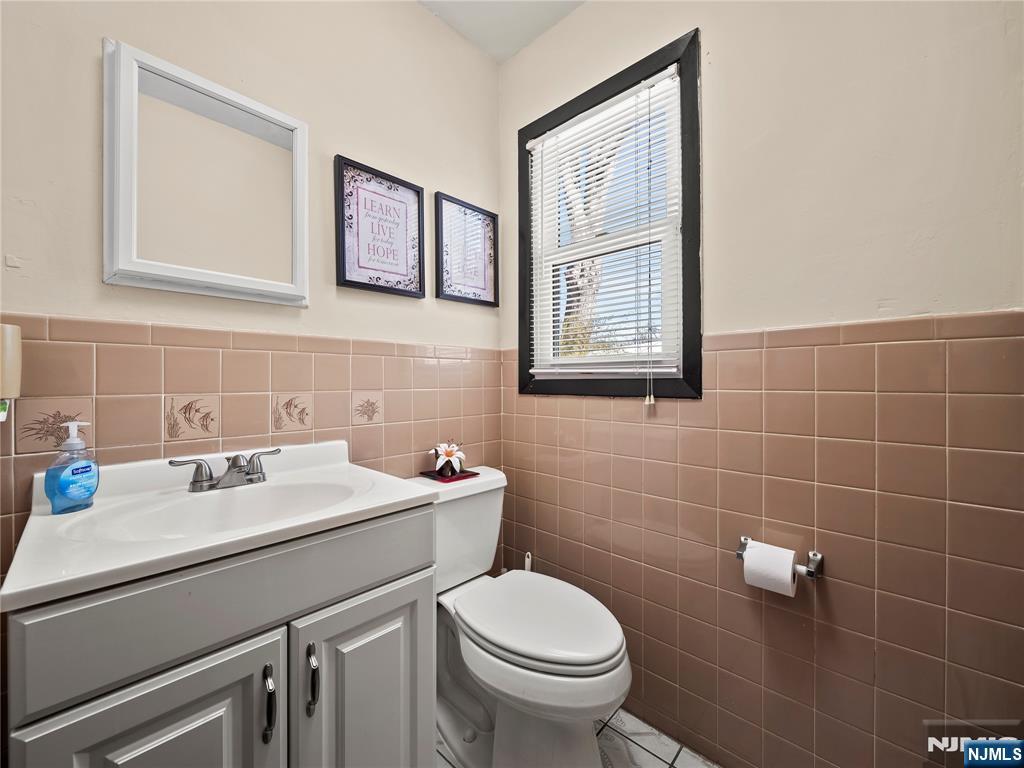 5 Woodland Road Bloomfield, NJ 07003 - Photo 11 of 30 a bathroom with a sink a toilet and a mirror