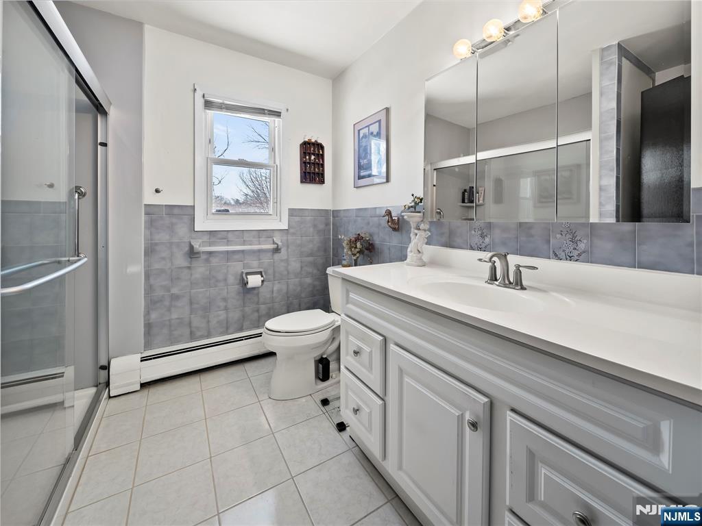 5 Woodland Road Bloomfield, NJ 07003 - Photo 19 of 30 a spacious bathroom with a double vanity sink toilet and shower