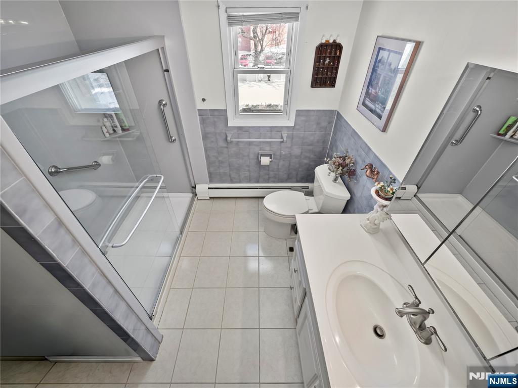 5 Woodland Road Bloomfield, NJ 07003 - Photo 20 of 30 a bathroom with a sink and mirror with bathtub
