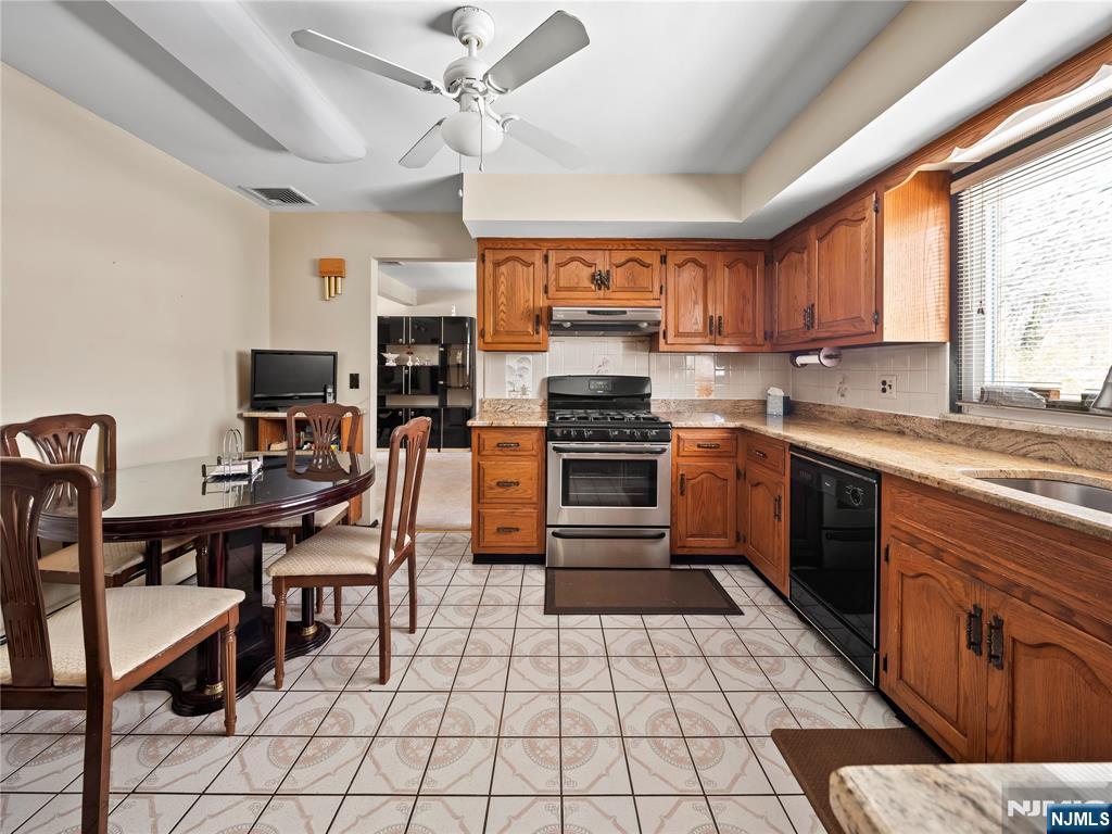 5 Woodland Road Bloomfield, NJ 07003 - Photo 10 of 30 a kitchen with stainless steel appliances a table chairs sink and cabinets
