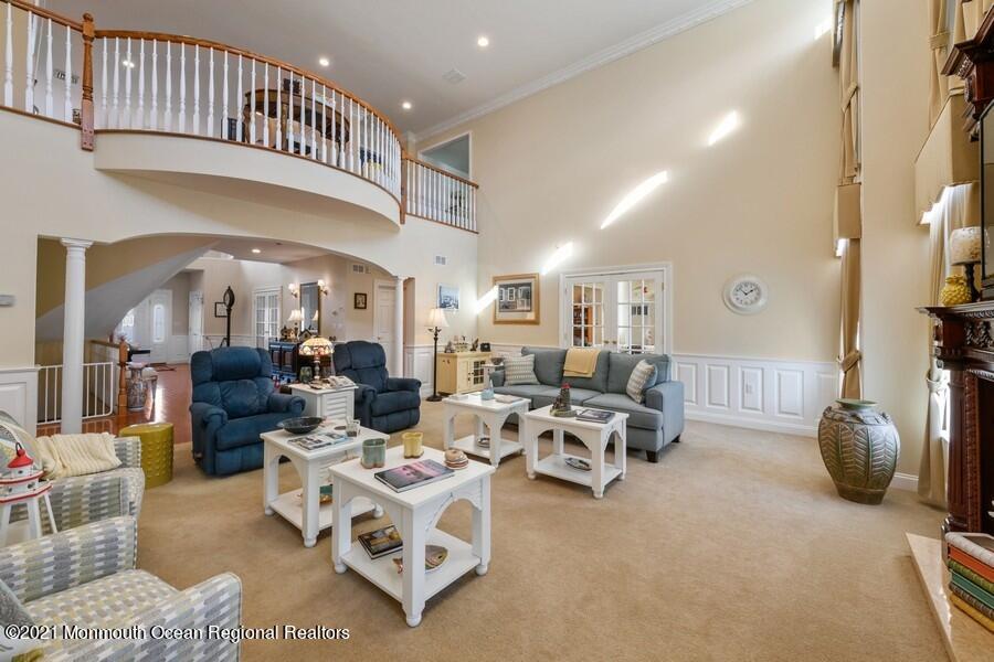 179 Stone Hill Road Colts Neck, NJ 07722 - Photo 21 of 57 a living room with furniture gym equipment and a chandelier