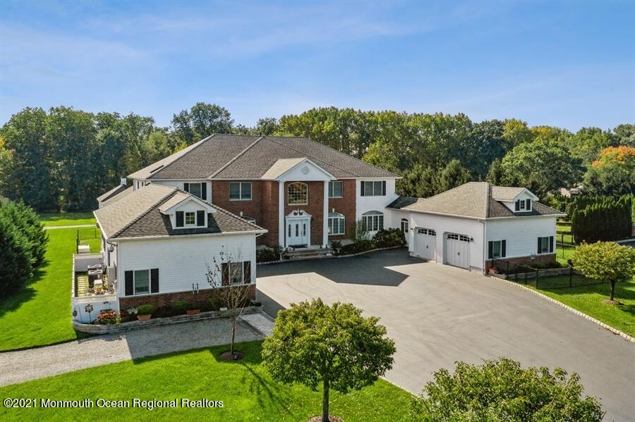 179 Stone Hill Road Colts Neck, NJ 07722 - Photo 47 of 57 a front view of a house with a yard and garage