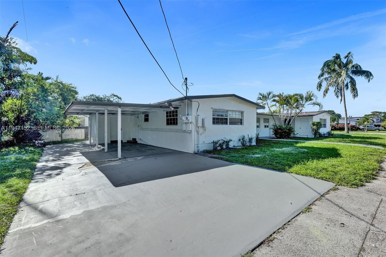 5657 Grant Street, Unit 2 Hollywood, FL 33021 - Photo 13 of 13 a front view of a house with a yard and garage