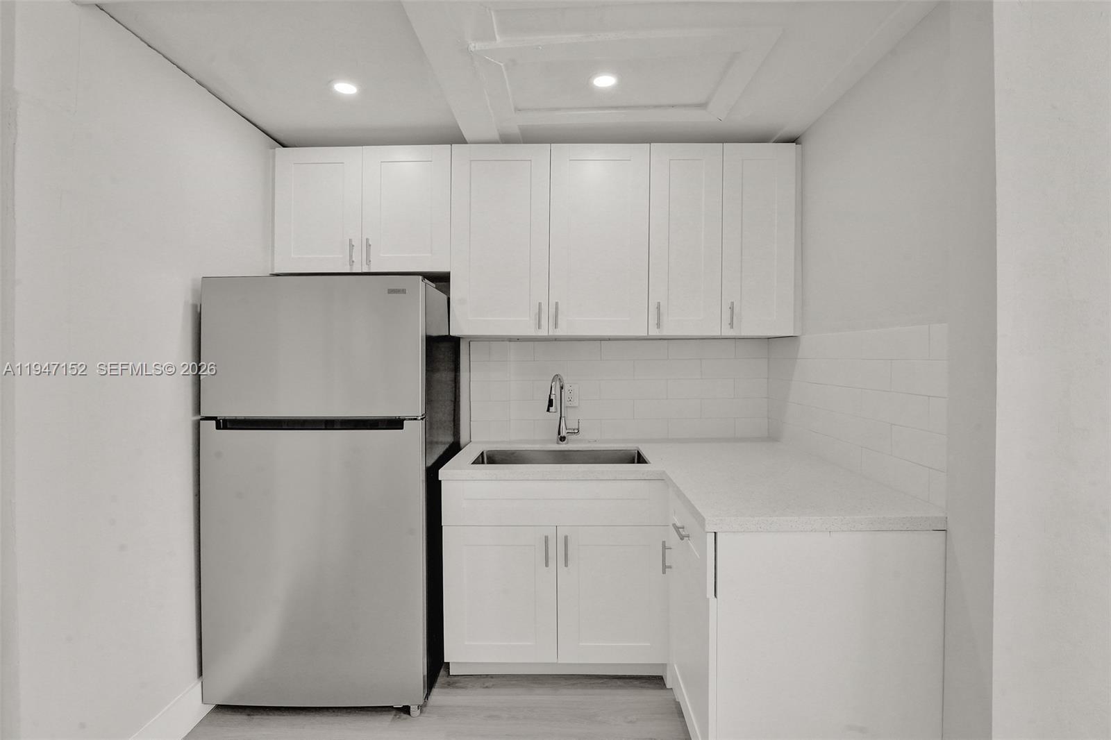 5657 Grant Street, Unit 2 Hollywood, FL 33021 - Photo 6 of 13 a view of a refrigerator and cabinets in a kitchen