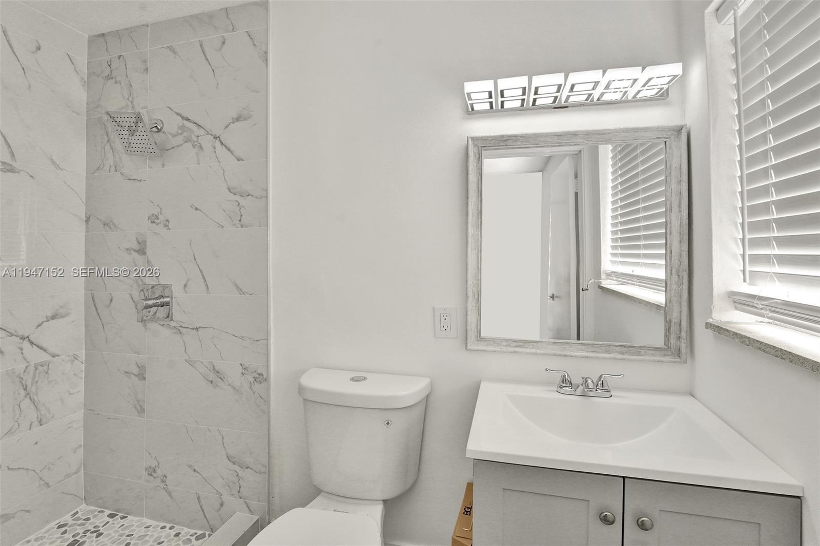 5657 Grant Street, Unit 2 Hollywood, FL 33021 - Photo 8 of 13 a bathroom with a sink and a mirror