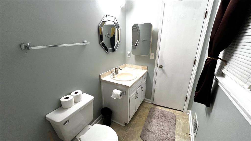 975 Ridgedale Drive Lawrenceville, GA 30043 - Photo 12 of 31 a bathroom with a toilet sink and mirror